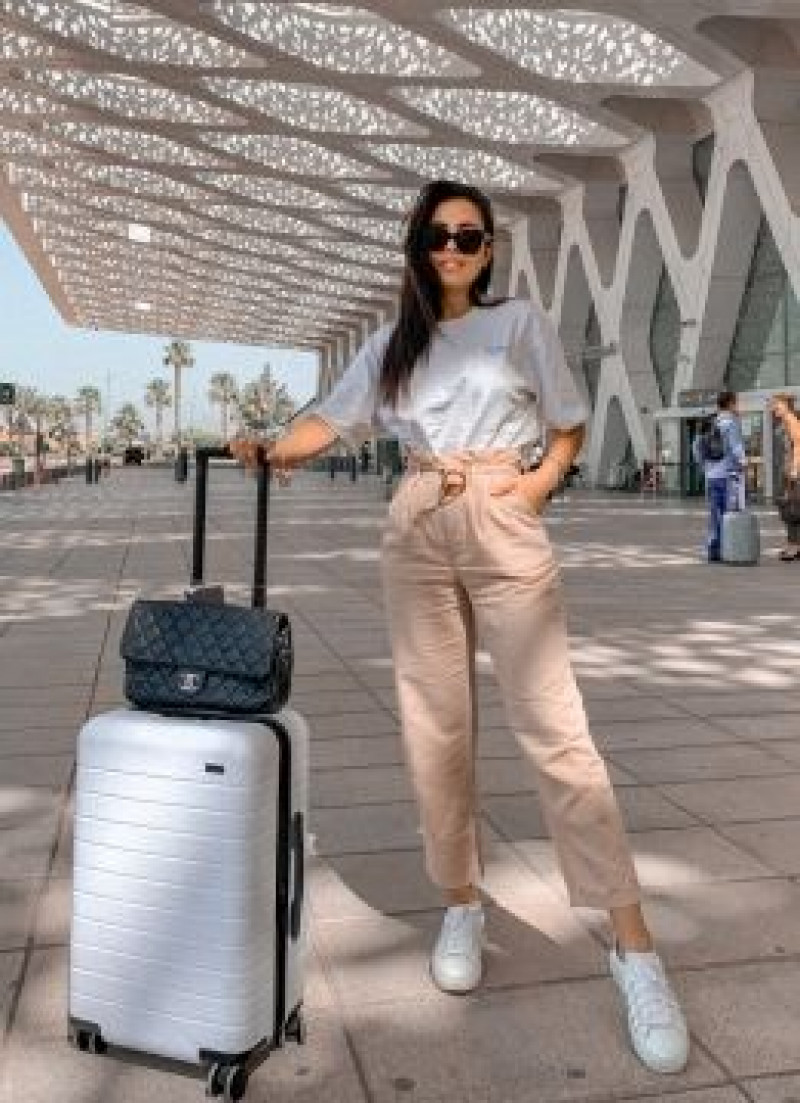 comfy airport outfits, dubai international airport, luggage and bags, airport fashion, dana berez, beige casual trouser, white t-shirt, white sneaker