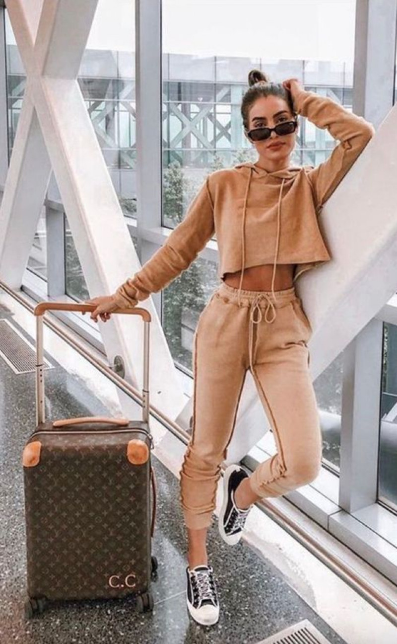 airport outfits, airport fashion, travel fashion, dana berez, beige sweatshirt, pink casual trouser, multicolor sneaker