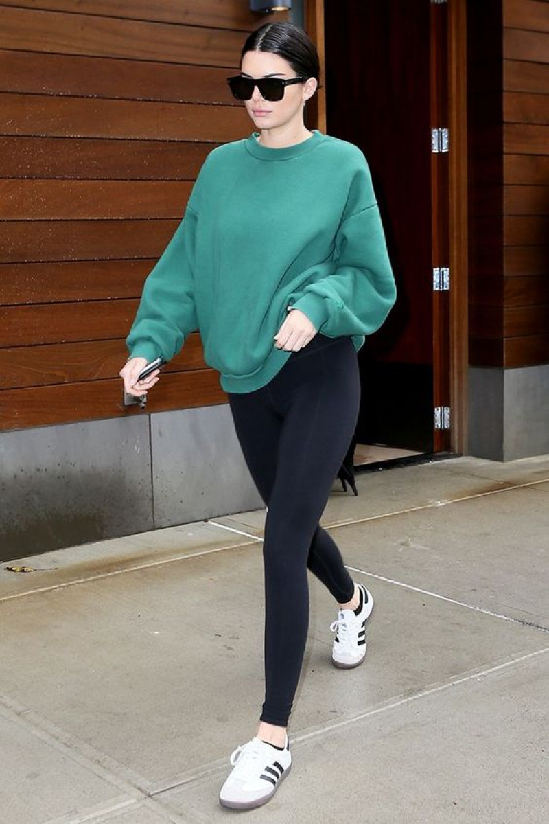 kendall jenner leggings outfits, sweatshirt + leggings, kendall + kylie, shiny leggings, kendall jenner, active pants, yoga pant, turquoise sweater, black legging, white sneaker, white trainer